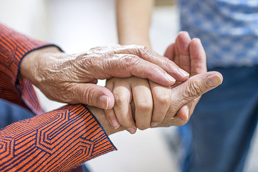 close-up of an elderly person's hand holding a younger looking hand