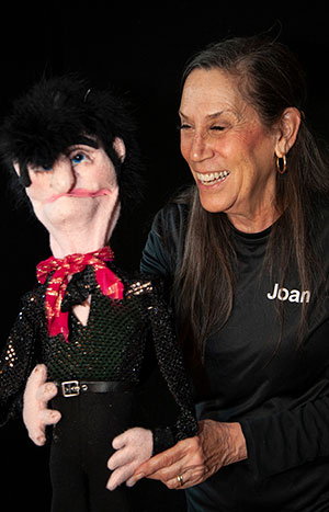 Joan Klasson laughing with a puppet.